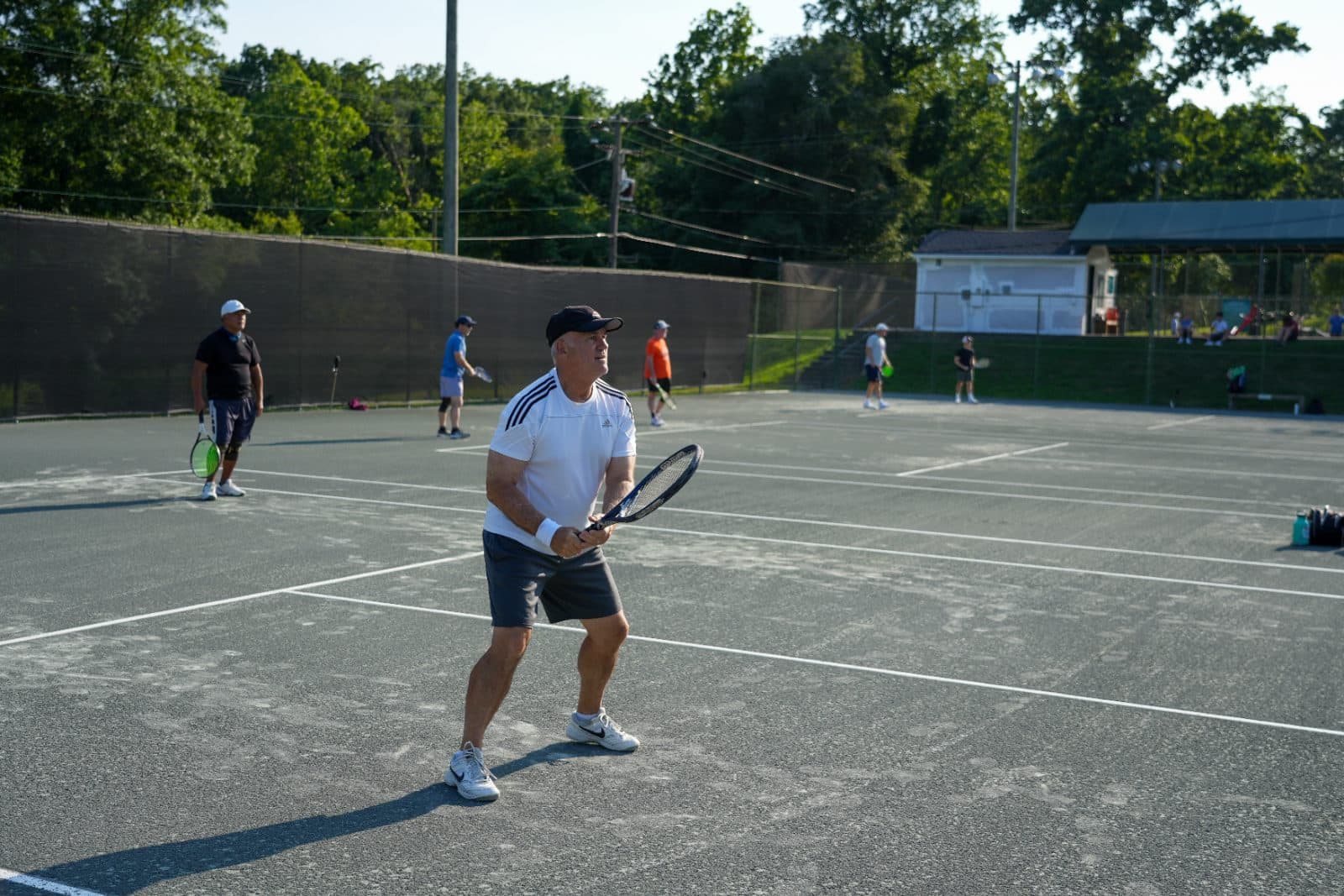 A member returning a forehand on one of the Har-Tru clay courts